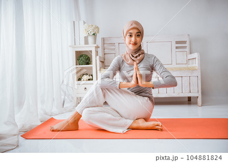 muslim woman instructor wearing hijab yoga pilates half fish pose mattress 104881824
