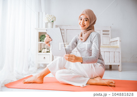 muslim hijab woman watching home work out tutorial from tablet 104881828