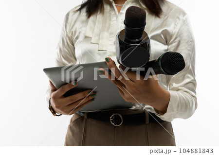 a female journalist standing bring two microphone and a tablet 104881843