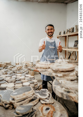 smiling stone craft worker man showing thumbs up in a warehouse 104881846