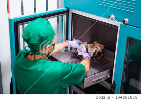 male hospital employee wearing uniform while storing blood bag in storage 104881958