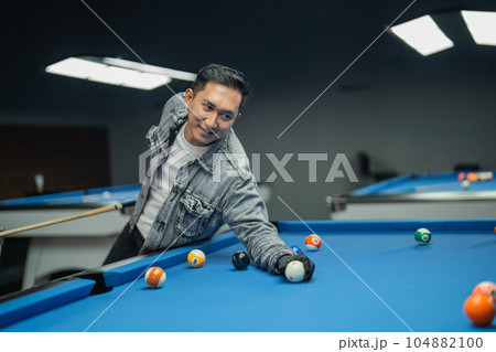 handsome billiard player positioning the cue ball handsome billiard player positioning the cue ball 104882100