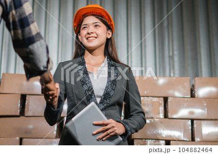 young female worker in suit shakes hands during dealings with clients 104882464