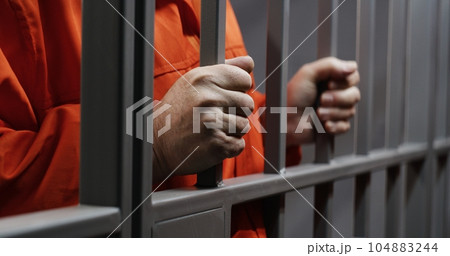 Hands close up of elderly prisoner holding metal bars 104883244