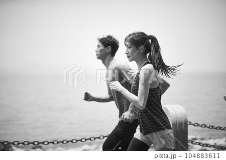 young asian man and woman running outdoors young asian man and woman running outdoors 104883611