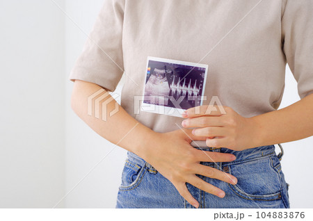 妊娠検査のエコー写真を持つ若い女性 妊娠検査のエコー写真を持つ若い女性 104883876