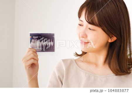 妊娠検査のエコー写真を持つ若い女性 妊娠検査のエコー写真を持つ若い女性 104883877