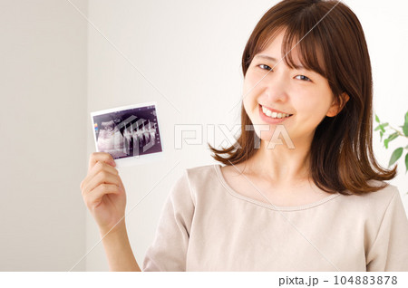 妊娠検査のエコー写真を持つ若い女性 妊娠検査のエコー写真を持つ若い女性 104883878