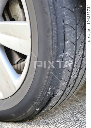 Close-up shallow focus shot of an old worn-out tire with cracks. Seems to be dangerous for drivers and passengers. It should be replaced immediately for safety. as a reminder to keep safe. 104885734