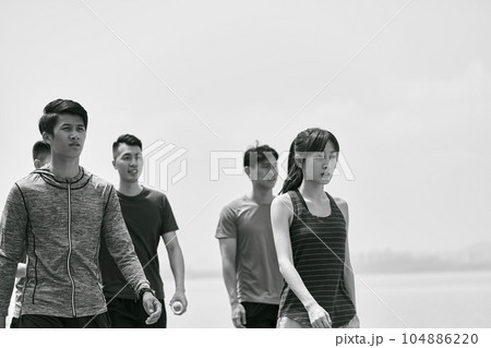 group of five young asian adults taking a walking outdoors after exercising, black and white 104886220