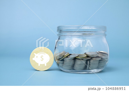 Coins in glass jar with virtual piggy bank on wooden block, Financial business investment, Growing money, People saving money, Money saving for future concept 104886951