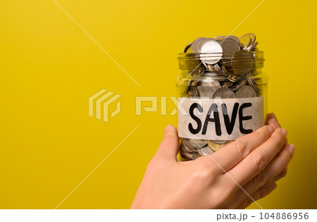Hand holding coins in glass jar, Financial business investment, Growing money, People saving money, Money for future, Money saving concept Hand holding coins in glass jar, Financial business investment, Growing money, People saving money, Money for future, Money saving concept 104886956