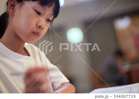 学校の自習室で宿題をしている小学生の女の子の様子 104887729