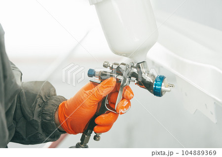Airbrush paint gun in paint in car service station 104889369