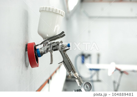 Airbrush paint gun in paint in car service station Airbrush paint gun in paint in car service station 104889481