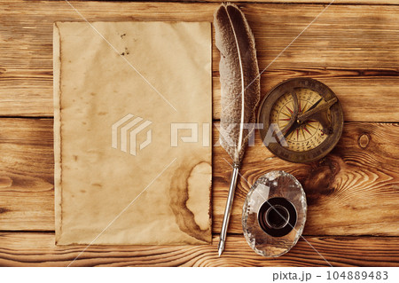 Old paper on brown wood background with feather Old paper on brown wood background with feather 104889483