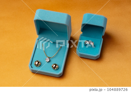 Blue boxes with golden jewelry on orange background 104889726