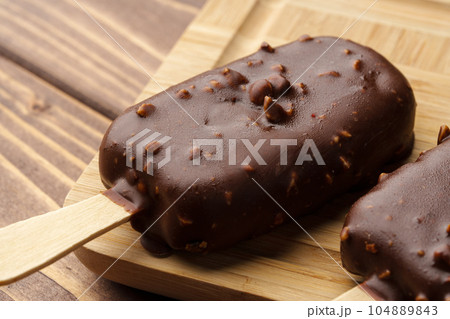 Chocolate cake pops ice creams on wooden board close up Chocolate cake pops ice creams on wooden board close up 104889843