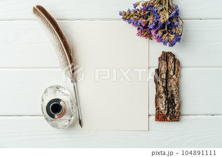 Blank letter, dry flowers and antique feather pen on wooden background Blank letter, dry flowers and antique feather pen on wooden background 104891111