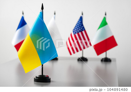 Small country flags standing at a table 104891480