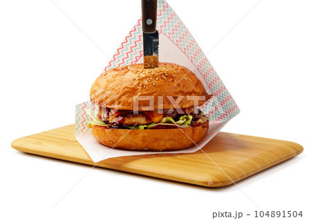 Delicious burger on wooden board isolated on white background Delicious burger on wooden board isolated on white background 104891504