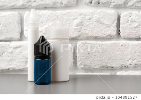 Refill liquid for electronic cigarettes against brick wall background 104891527