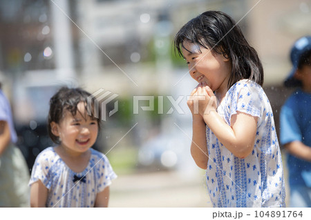 広場の噴水で水遊びしている女の子 104891764