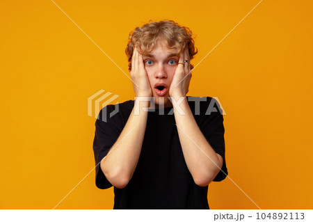 Young man over yellow background with surprise facial expression Young man over yellow background with surprise facial expression 104892113