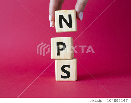 NPS - Net Promoter Score symbol. Wooden cubes with words NPS. Businessman hand. Beautiful red background. Business and NPS concept. Copy space. NPS - Net Promoter Score symbol. Wooden cubes with words NPS. Businessman hand. Beautiful red background. Business and NPS concept. Copy space. 104893147
