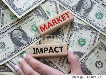Market impact. Concept word Market impact on wooden cubes. Beautiful dollar background. Businessman hand. Business and Market impact concept. Copy space. 104893246