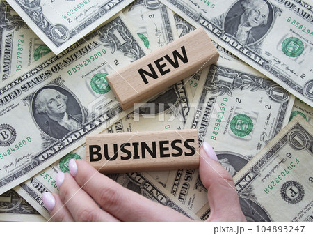 New business symbol. Concept words New business on wooden blocks. Businessman hand. Beautiful dollar background. Business and New business concept. Copy space. 104893247