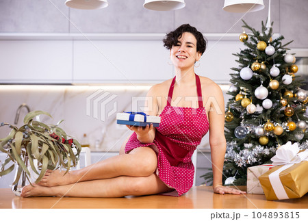 Half-naked woman sits on table with present Half-naked woman sits on table with present 104893815