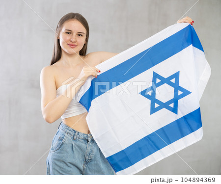 Girl holds unfolded canvas flag of Israel 104894369