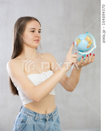 Portrait of young student girl with a globe in her hands 104894370