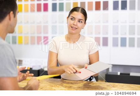 Friendly girl, sales assistant of paints store consulting buyer 104894694
