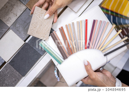 Woman architect designer select epoxy grout ceramic tiles compare samples finishing works concept 104894695