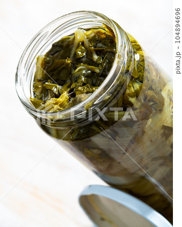 Glass jar with pickled swiss chard 104894696