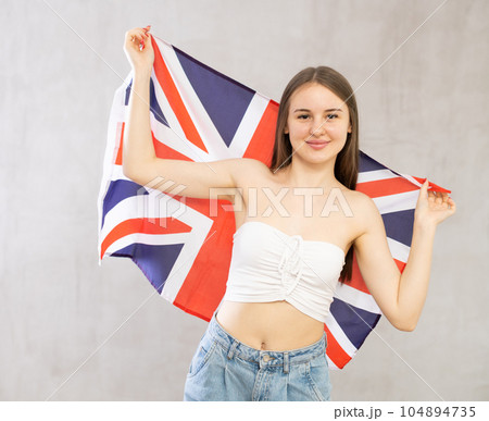 Pretty girl holding theGreat Britain flag in her hands Pretty girl holding theGreat Britain flag in her hands 104894735