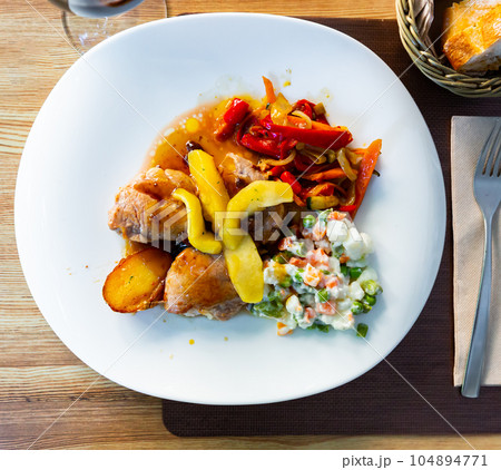 Grilled pork sirloin served with caramelized apple, stewed peppers and salad Grilled pork sirloin served with caramelized apple, stewed peppers and salad 104894771