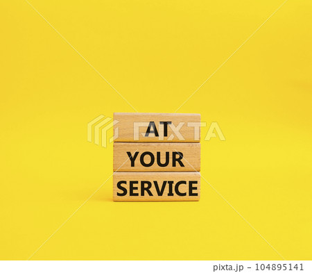 At your service symbol. Wooden blocks with words At your service. Beautiful yellow background. Business and At your service concept. Copy space. At your service symbol. Wooden blocks with words At your service. Beautiful yellow background. Business and At your service concept. Copy space. 104895141
