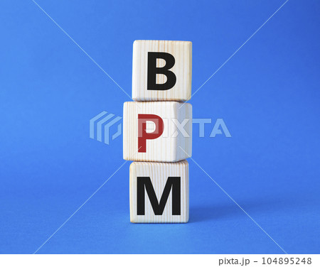BPM - Business Process Management symbol. Wooden cubes with words BPM. Beautiful blue background. Business and BPM concept. Copy space. 104895248