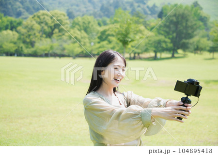 公園でV-log自撮りをする私服女性 104895418