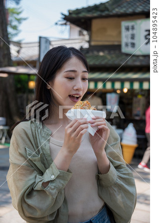 おかきを食べる私服女性 104895423