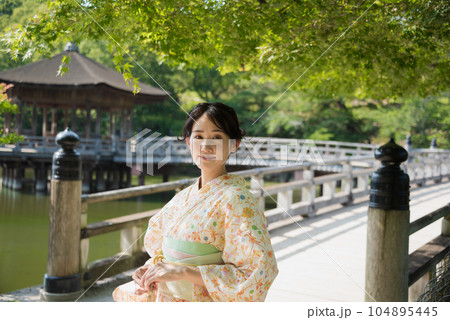 新緑の観光地で佇む笑顔の着物女性 104895445