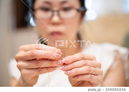 針に糸を通す女性 104895836