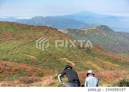 休息中の登山者と全山紅葉の栗駒山 休息中の登山者と全山紅葉の栗駒山 104896197
