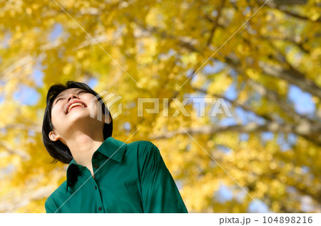 紅葉したイチョウ並木を楽しむ女性 紅葉したイチョウ並木を楽しむ女性 104898216