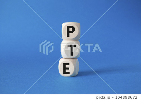 PTE - Pearson Tests of English symbol. Wooden cubes with word PTE. Beautiful blue background. Business and PTE concept. Copy space. 104898672