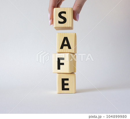 Safe symbol. Concept word Safe on wooden cubes. Businessman hand. Beautiful white background. Business and Safe concept. Copy space. 104899980