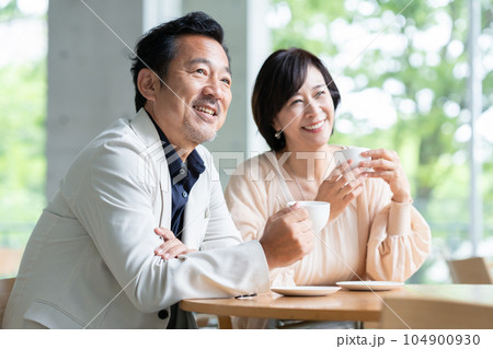 カフェでコーヒーを飲んで会話をする夫婦 104900930